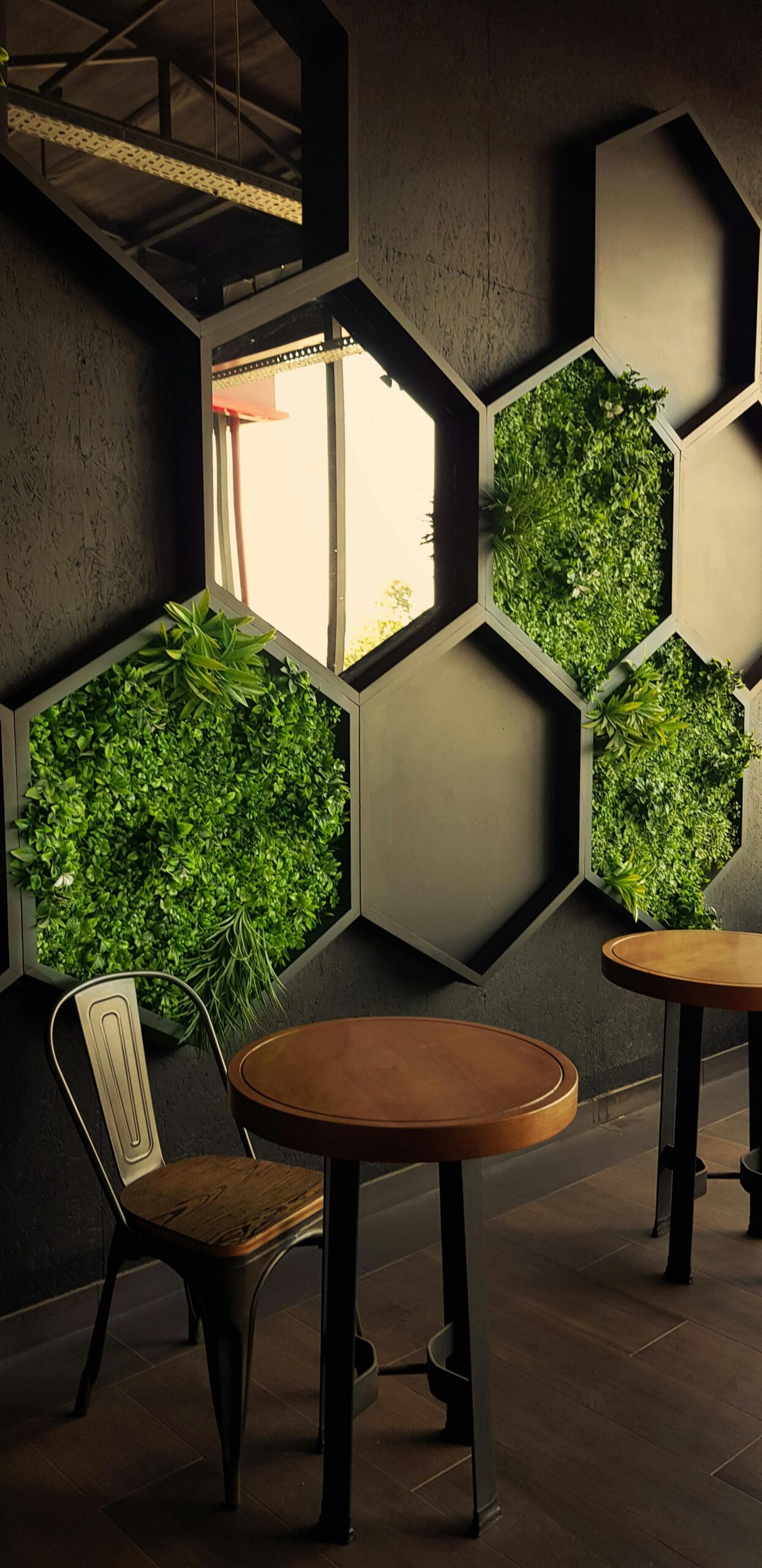 Stylish cafe interior featuring hexagonal green wall art and minimalist furniture.